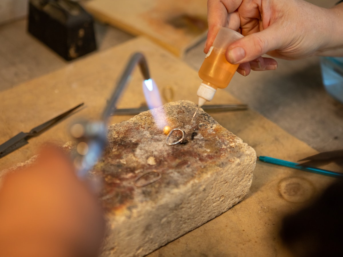 Jeweller soldering a silver ring with a torch