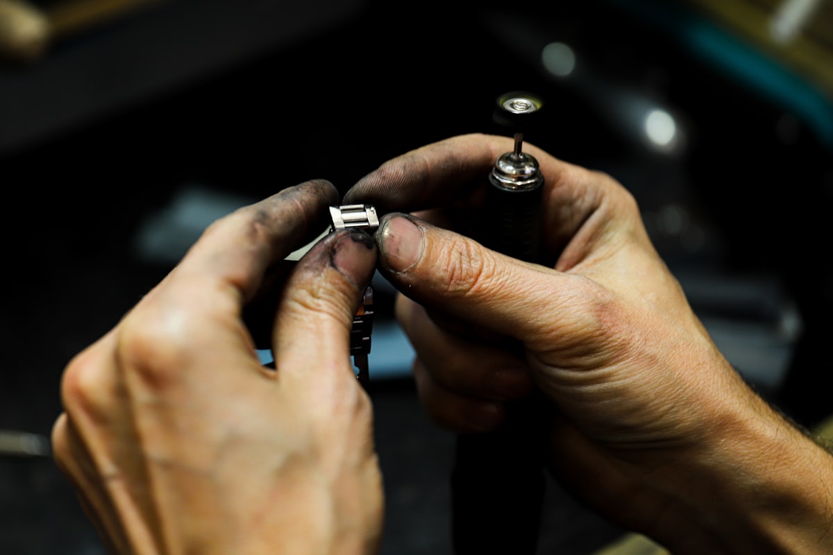 Maker working a metal piece by hand at the bench